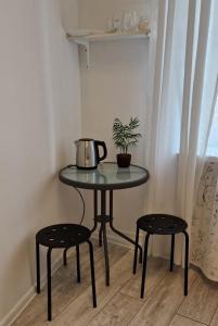a table with two stools and a tea pot on it at Prywatny pokój dla dwóch osób Pokój 2 in Warsaw