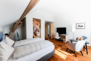 una sala de estar con un sofá blanco y una pintura del león en la pared en Landgasthof Leuen, en Uitikon