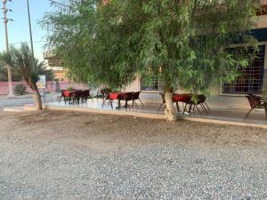un groupe de tables et de chaises sous un arbre dans l'établissement AMRAOUI Apartment, à Moulay Ali Chérif