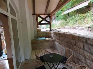 een patio met een tafel en stoelen en een stenen muur bij Annel's Träumerei in Radebeul
