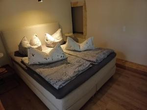 a bed with white pillows on it in a room at Annel's Träumerei in Radebeul