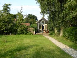 a small house in a field with a grass yard at The Studio in Hoe