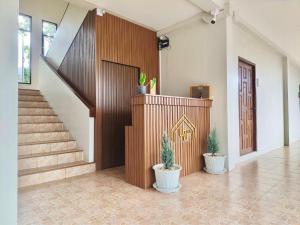 een hal met trappen en potplanten in een huis bij น่าน ม่วนใจ Nan Muanjai Hotel in Pua