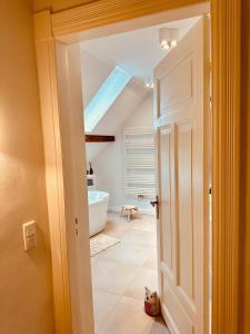 eine offene Tür zu einem Badezimmer mit einem Dachfenster in der Unterkunft Villa am Strand in Eckernförde