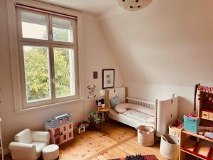 Cette chambre pour enfants comprend un lit et une fenêtre. dans l'établissement Villa am Strand, à Eckernförde
