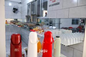 uma cozinha com muitas garrafas e copos num balcão em Pousada Ju&Ju à 400 mts DA PRAIA em Pontal do Paraná
