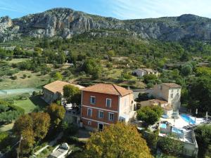 a small village with a mountain in the background at Hôtel Le Colombier in Moustiers-Sainte-Marie