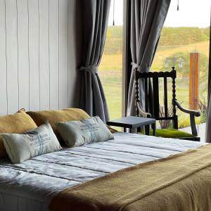 uma cama grande num quarto com uma janela em ROCCHETTA HOTEL BOUTIQUE em Sierra de los Padres