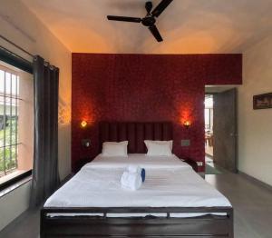 a bedroom with a large bed with a ceiling fan at Breeze The Hills By Stayvilla in Trimbak