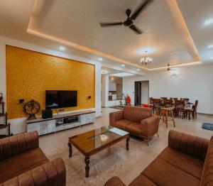 a living room with couches and a flat screen tv at Breeze The Hills By Stayvilla in Trimbak