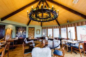 a dining room with a chandelier and a table and chairs at The Cock and Bull in Balmedie