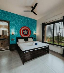 a bedroom with a captain america painting on the wall at Breeze The Hills By Stayvilla in Trimbak