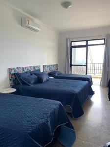 ein Hotelzimmer mit 2 Betten und einem Fenster in der Unterkunft Maravilhosa casa em Vilas do Atlantico frente ao mar in Lauro de Freitas