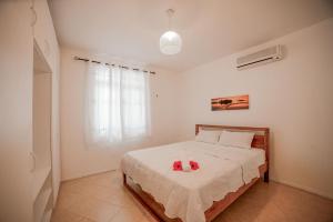 a bedroom with a bed with two stuffed animals on it at Maison à 5 mins de la plage et des commerces in Flic-en-Flac +4 photos
