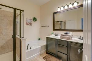 a bathroom with a tub and a sink and a mirror at Covered Patio and Large yard Mansfield Home in Mansfield +21 photos