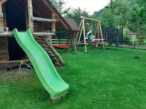 a green slide on a playground in a yard at Casa Ilinca in Şimon
