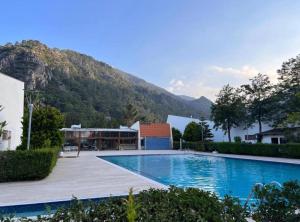 a large swimming pool with a mountain in the background at Magic mountain villas in Antalya