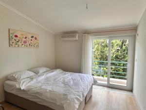 ein Schlafzimmer mit einem Bett und einem großen Fenster in der Unterkunft Magic mountain villas in Antalya
