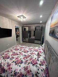 a bedroom with a bed with a floral bedspread at Apartament Jodłowa in Kołobrzeg