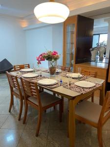 a dining room table with plates and flowers on it at APARTAMENTO SOL E MAR VITÓRIA in Vitória +9 photos