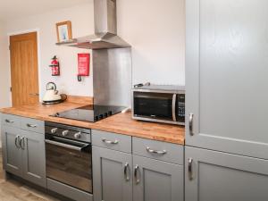 a kitchen with a microwave oven and a stove at Plover in Grindon