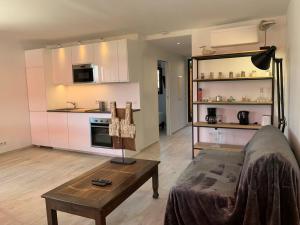 a living room with a couch and a table and a kitchen at Appartement neuf 4km Saint-Tropez in Saint-Tropez