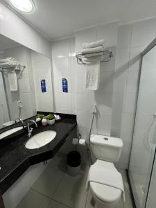 a bathroom with a white toilet and a sink at Gran Hotel Arrey in Teresina