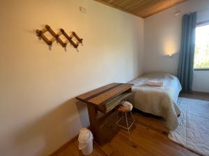 um quarto com uma cama e uma mesa de madeira em Hamilton's Place Bed and Breakfast em Ensenada
