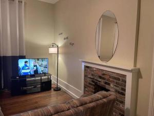 a living room with a television and a fireplace at Suite 3 - Sweet Macon Home in Macon