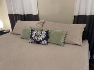a bed with several pillows on top of it at Suite 3 - Sweet Macon Home in Macon