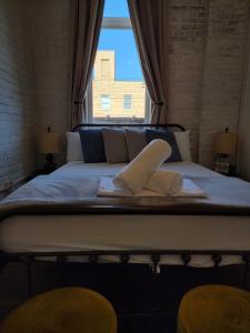 uma cama com duas toalhas num quarto com uma janela em HOSTEL Auberge Clarksdale em Clarksdale