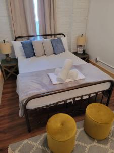 a bedroom with a bed with two yellow stools at HOSTEL Auberge Clarksdale in Clarksdale