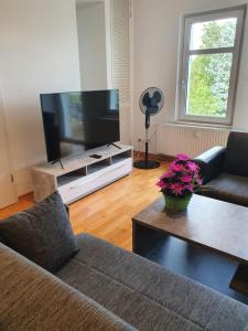 a living room with a couch and a flat screen tv at Unterkunft an der Karl-Marx Straße Leipzig in Leipzig
