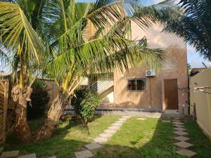a house with a palm tree in the yard at Fafape in Lomé