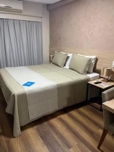een slaapkamer met een groot bed, een bureau en een computer bij Gran Hotel Arrey in Teresina