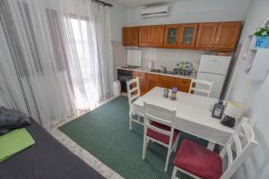 a small kitchen with a white table and chairs at Apartments TIM in Sveti Petar