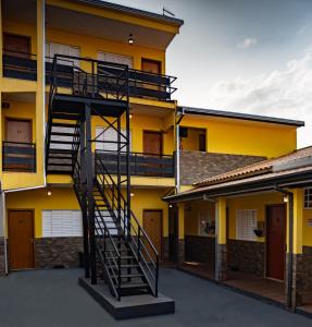 a spiral staircase is on the side of a yellow building at Hotel Nixon Próximo, Rodoviária, Prefeitura e a Matriz central in Itaí