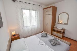 a bedroom with a bed and a mirror and a window at Apartments TIM in Sveti Petar