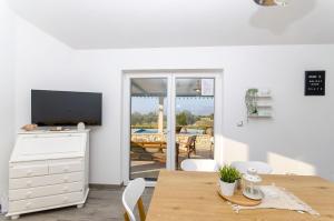 a living room with a table and a television and a table and chairs at House Blato in Postira
