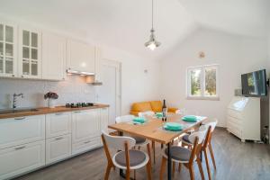 a kitchen with a table and chairs in a kitchen at House Blato in Postira +43 photos