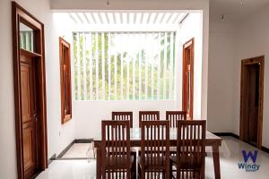 a dining room with a table and chairs and a window at Windy Villa in Polonnaruwa