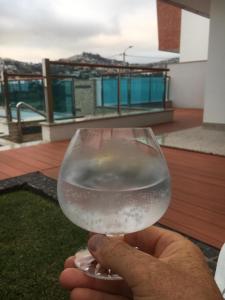 una persona che tiene in mano un bicchiere di vino di Moradia Vista Atlântico a Funchal