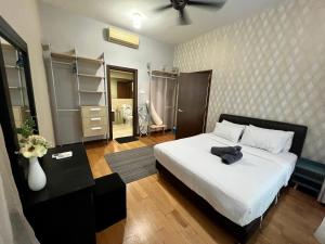 a bedroom with a white bed with a black head board at Luxury Regalia suites by adnan in Kuala Lumpur