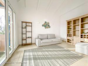a white living room with a couch and a rug at Tapia Hills in Methoni