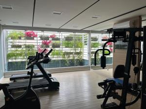 a gym with tread machines and a large window at House Park completo em Blumenau-SC in Blumenau