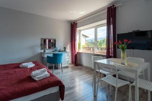 sypialnia ze stołem i łóżkiem oraz stołem i krzesłami w obiekcie Willa Sonata - Apartamenty & Balia - Szklarska Poręba w Szklarskiej Porębie