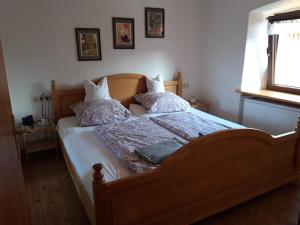 1 dormitorio con 1 cama de madera y 2 almohadas en Ferienhaus "Bei Koos", en Wiesbaum