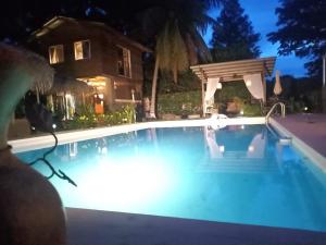 uma grande piscina à noite com uma pérgola em B&B EL Litoral em Playa Coronado