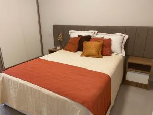 a bedroom with a large bed with pillows at House Park completo em Blumenau-SC in Blumenau