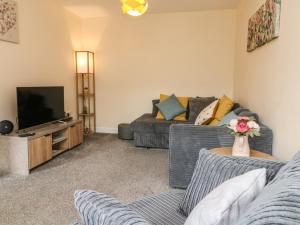 a living room with a couch and a tv at Sunny Views in Ilfracombe